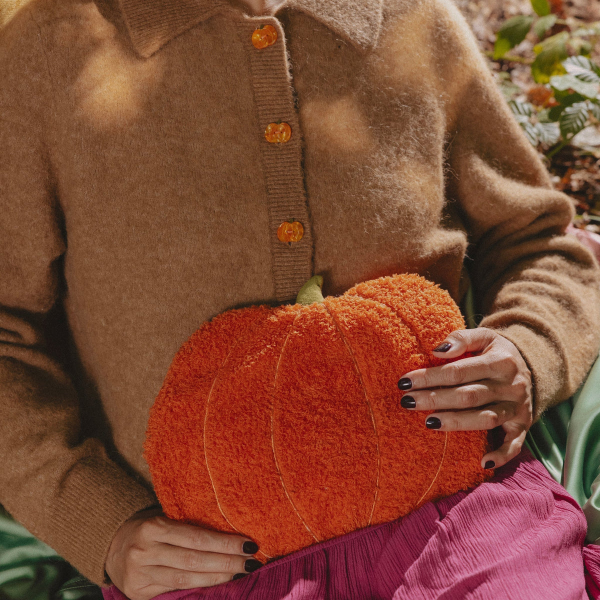 Bouillotte citrouille orange Coucou Suzette portée avec un cardigan marron