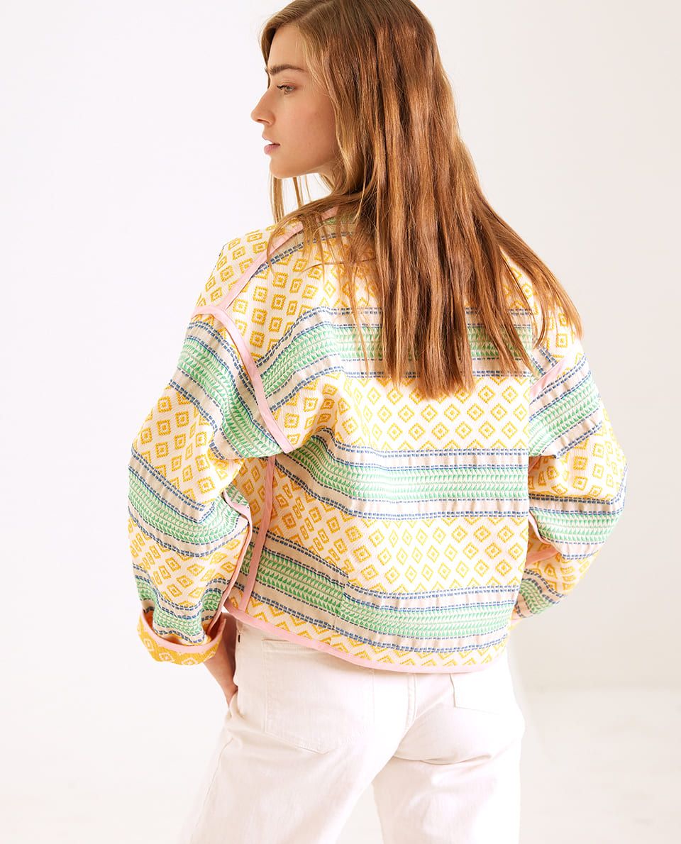 Veste à motifs jaunes et verts portée de dos