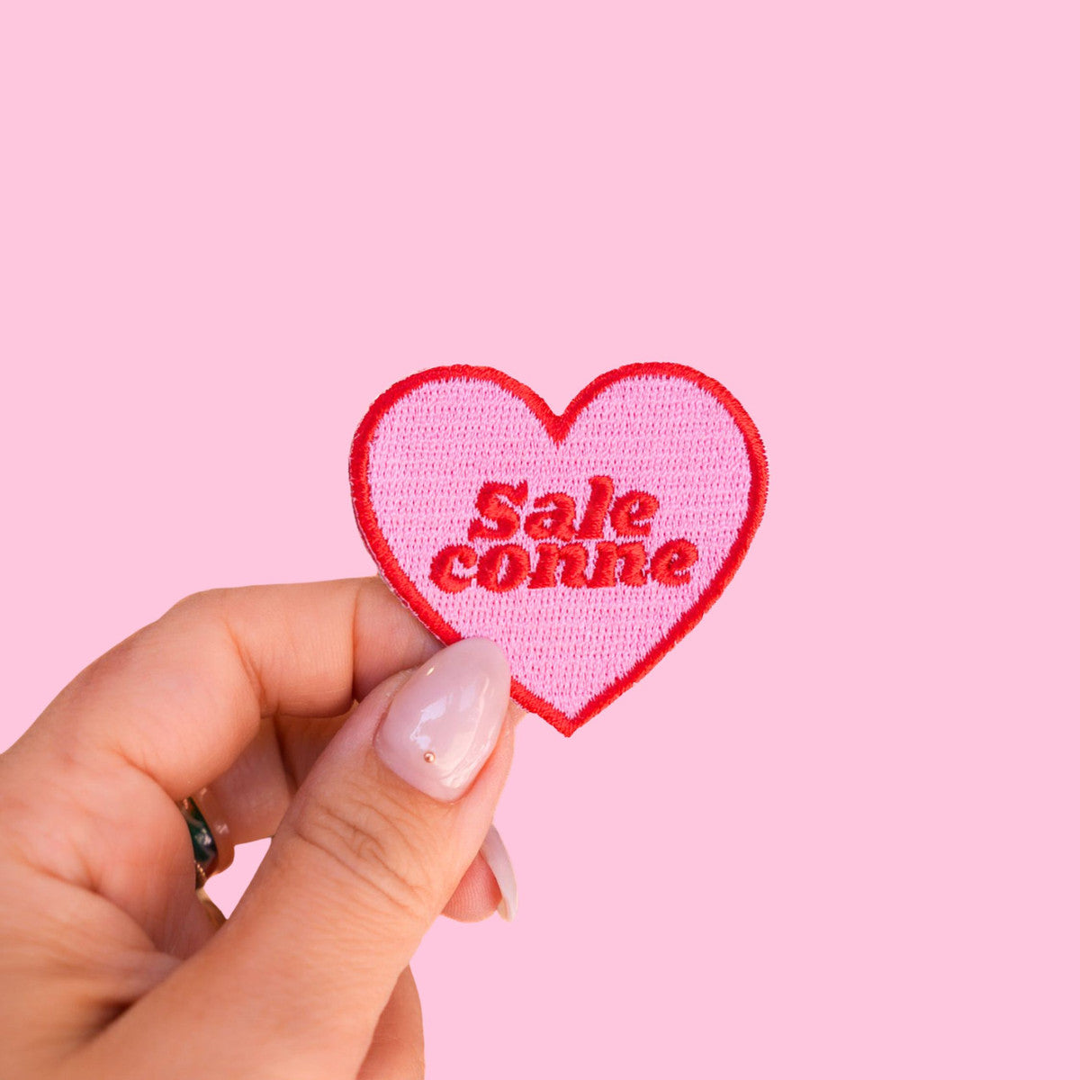 Patch thermocollant Sale Conne Malicieuse - Patch thermocollant Sale conne dans la main vue de face