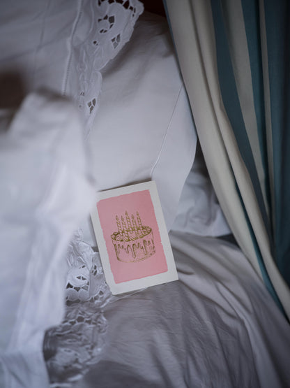 Carte anniversaire Gold Cake Archivist Gallery posée sur un lit