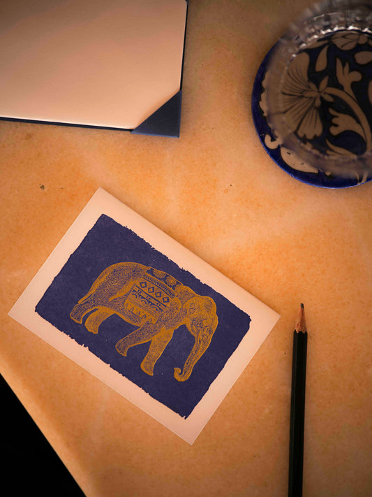 Carte Gold Elephant Archivist Gallery posée sur une table près d’un crayon