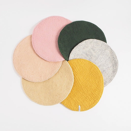 Coussins d’assise ronds en laine Aveva présentés dans plusieurs coloris