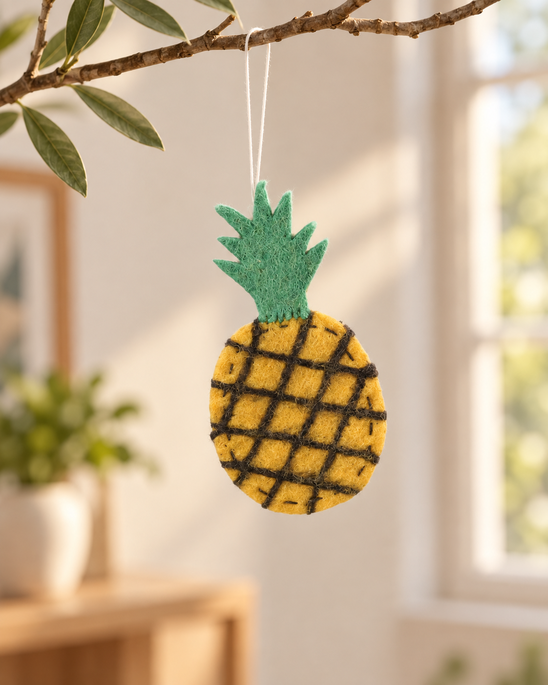 Ananas Aveva en laine suspendu à une branche, mise en situation reconstituée par IA