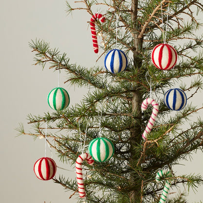 Décorations en laine Aveva mises en scène sur une branche, modèle rayures bleu et blanc