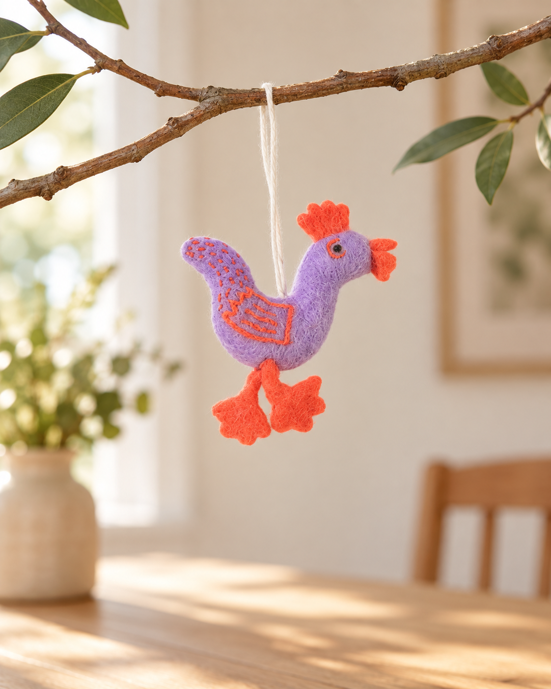 Coq Funky Rooster S lilas Aveva en laine suspendu à une branche, mise en situation reconstituée par IA
