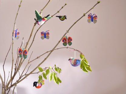 Décorations en laine Aveva suspendues en situation, avec le modèle Oiseau corail