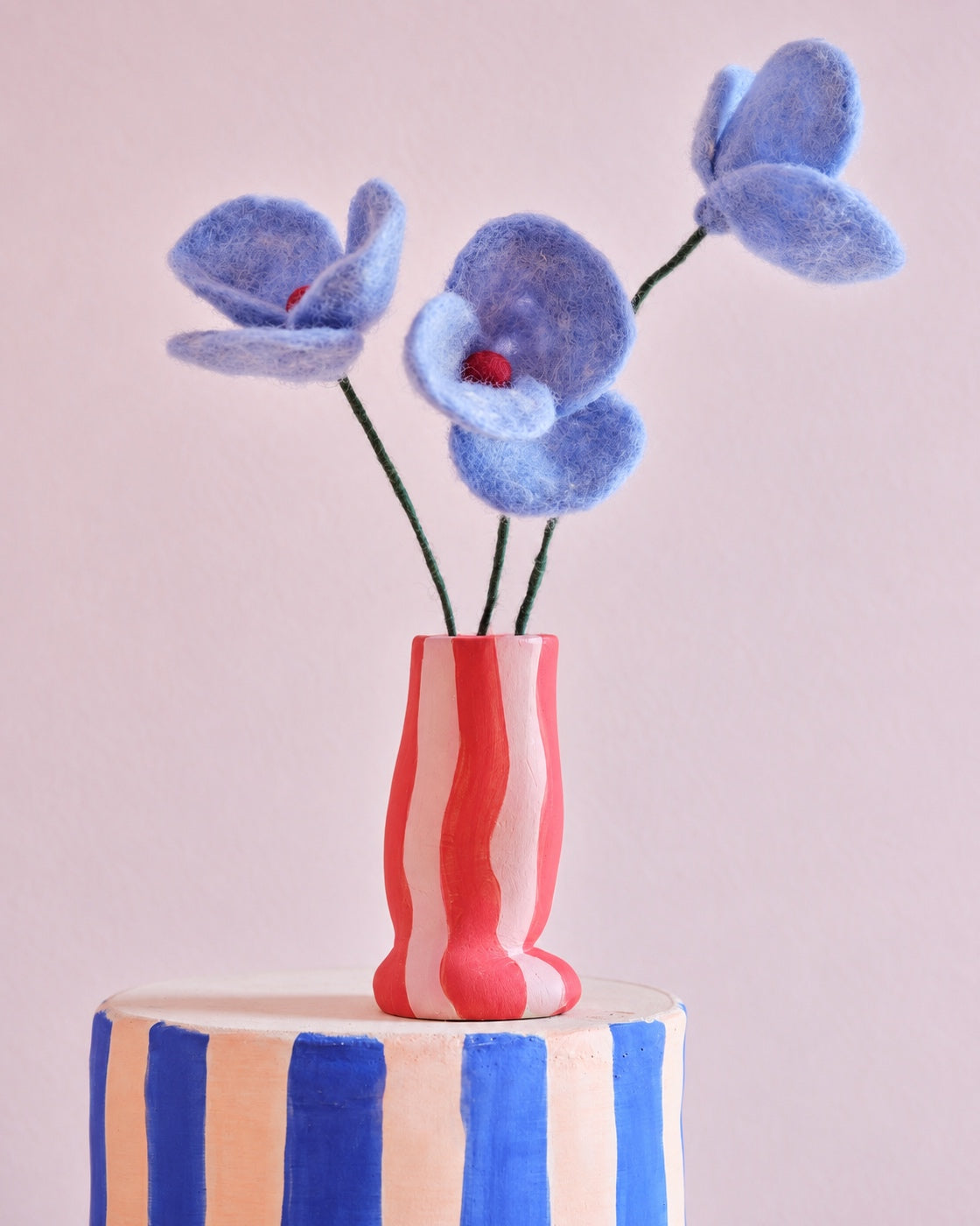 Trois fleurs Poppy bleues Aveva en laine dans un vase rayé
