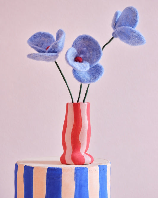 Trois fleurs Poppy bleues Aveva en laine dans un vase rayé