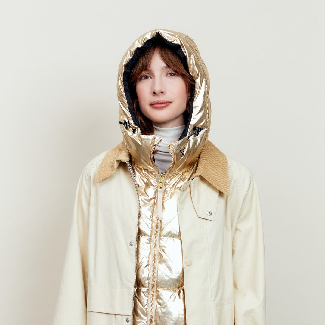 Capuche Fudoon dorée relevée, portée sous un trench beige