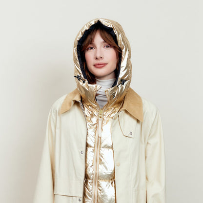 Capuche Fudoon dorée relevée, portée sous un trench beige
