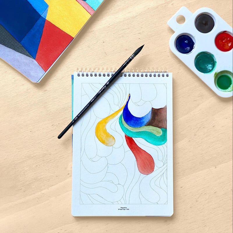 Carnet d’aquarelle Papier Tigre en cours de peinture avec pinceau et palette