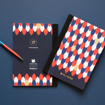 Carnets Élysée Cocorico Papier Tigre mis en scène sur fond bleu