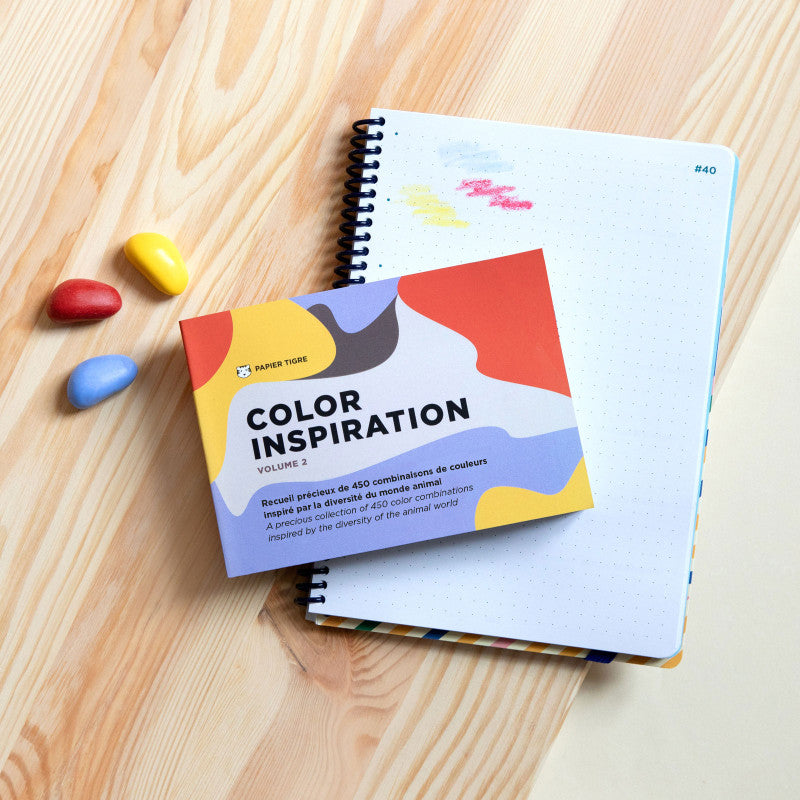 Livre Color Inspiration Volume 2 Papier Tigre posé sur un carnet bleu