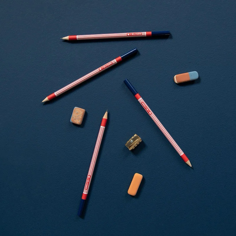 Crayons Élysée Papier Tigre mis en scène avec des gommes sur fond bleu