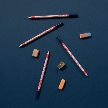Crayons Élysée Papier Tigre mis en scène avec des gommes sur fond bleu