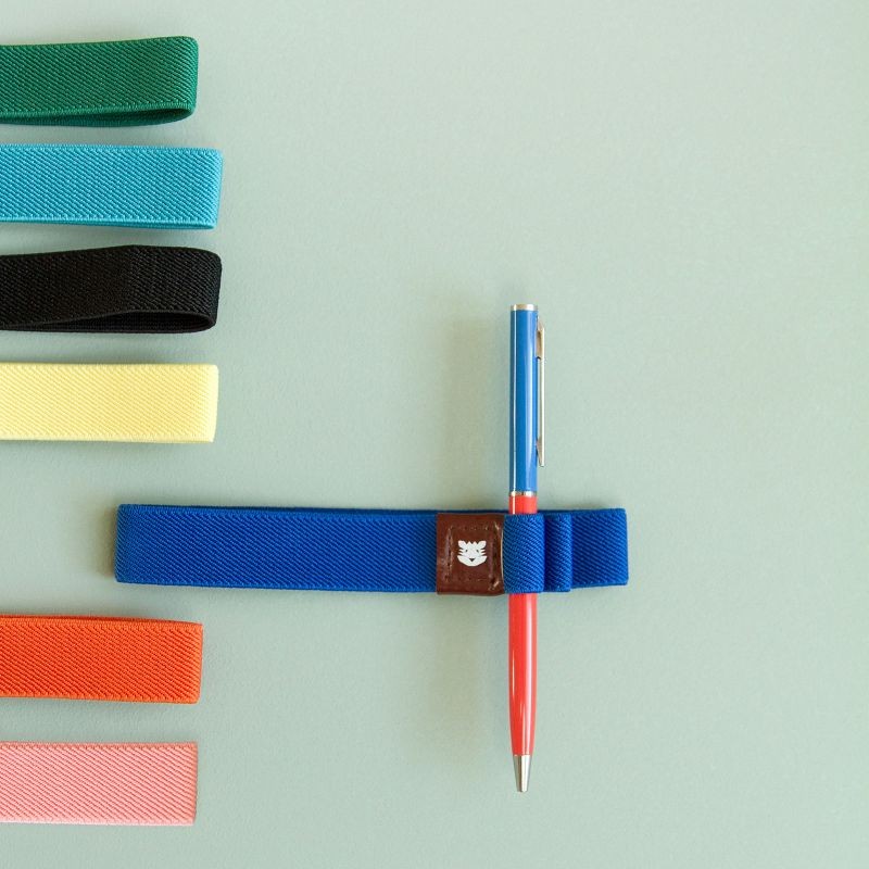 Élastique Le Voyageur Papier Tigre utilisé pour maintenir un stylo